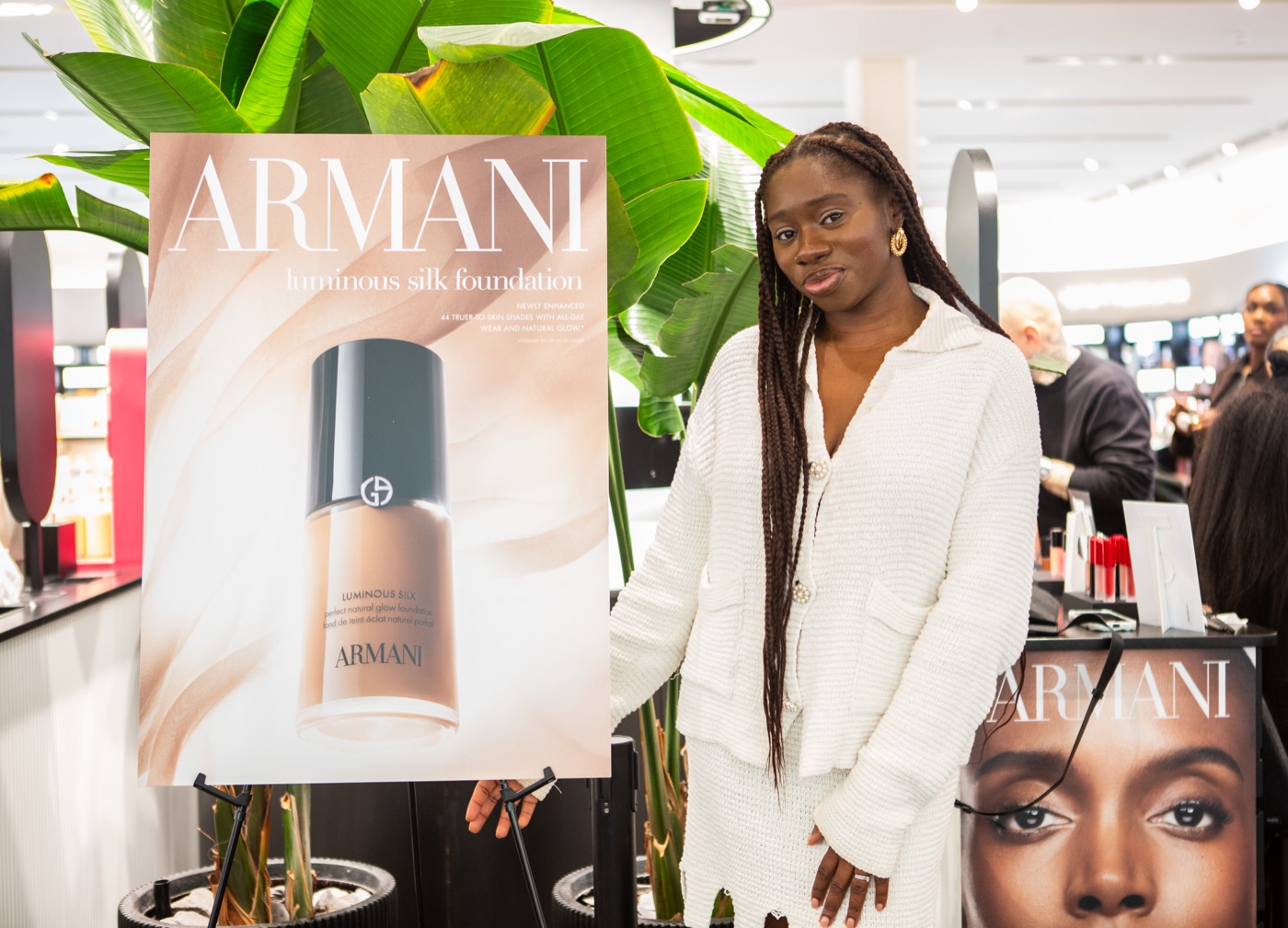 A guest in a white knit beside the Armani Luminous Silk foundation display at the Armani Beauty Luminous Silk Foundation masterclass