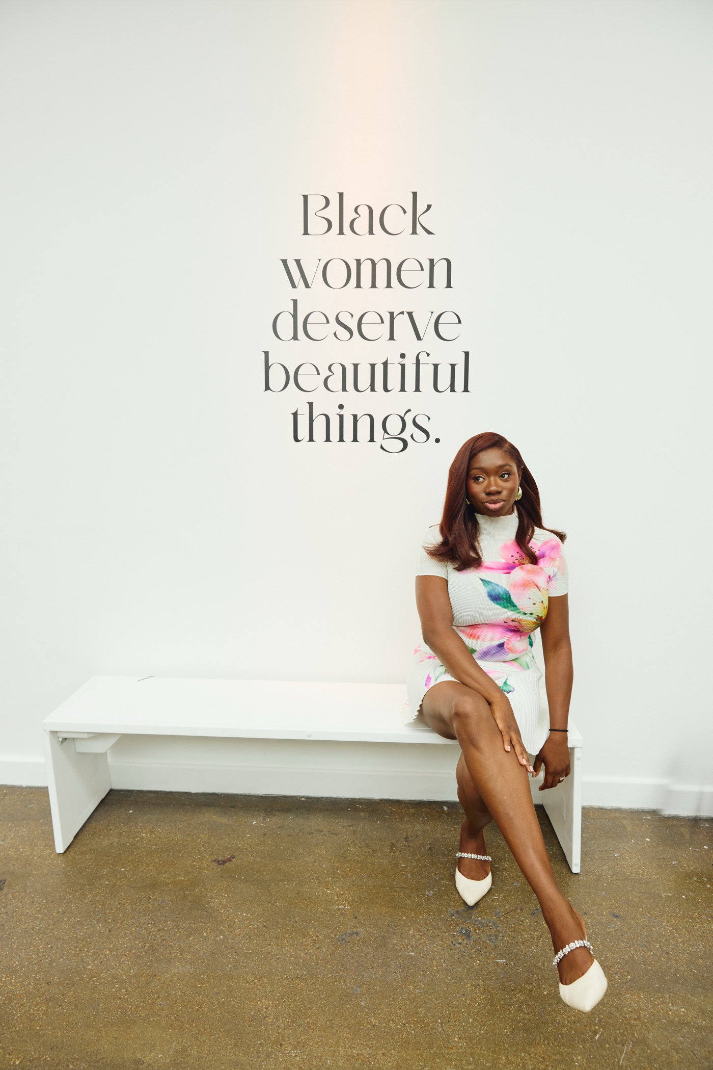 Tobi Oredein seated beneath the words Black women deserve beautiful things at the Black Ballad Weekender 2026