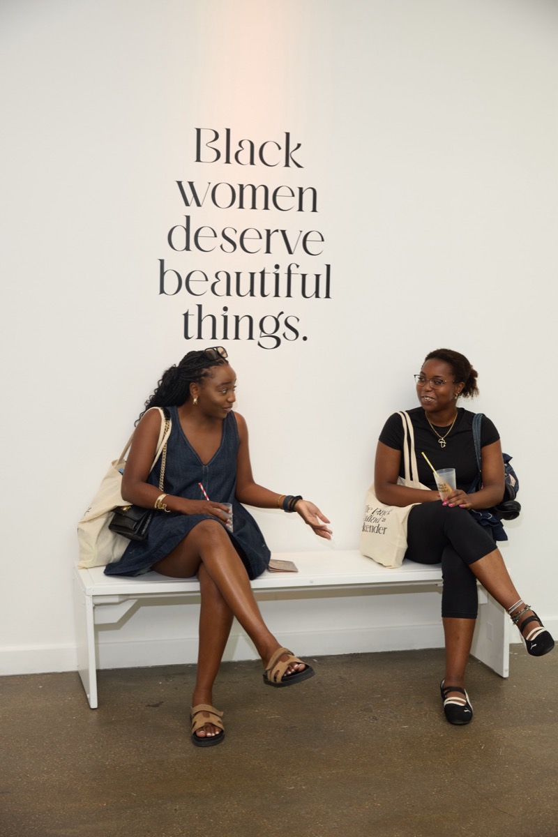 Two guests seated beneath the words Black women deserve beautiful things