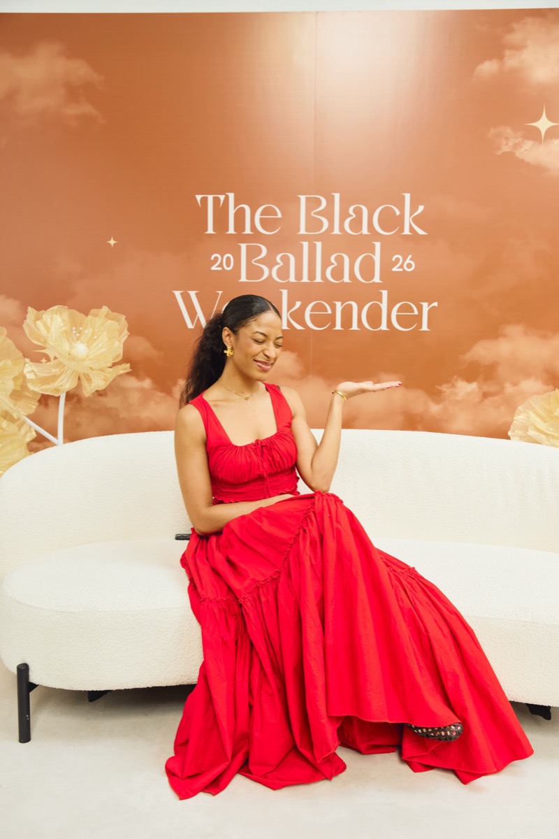 A guest in a red dress on the Weekender photo wall sofa