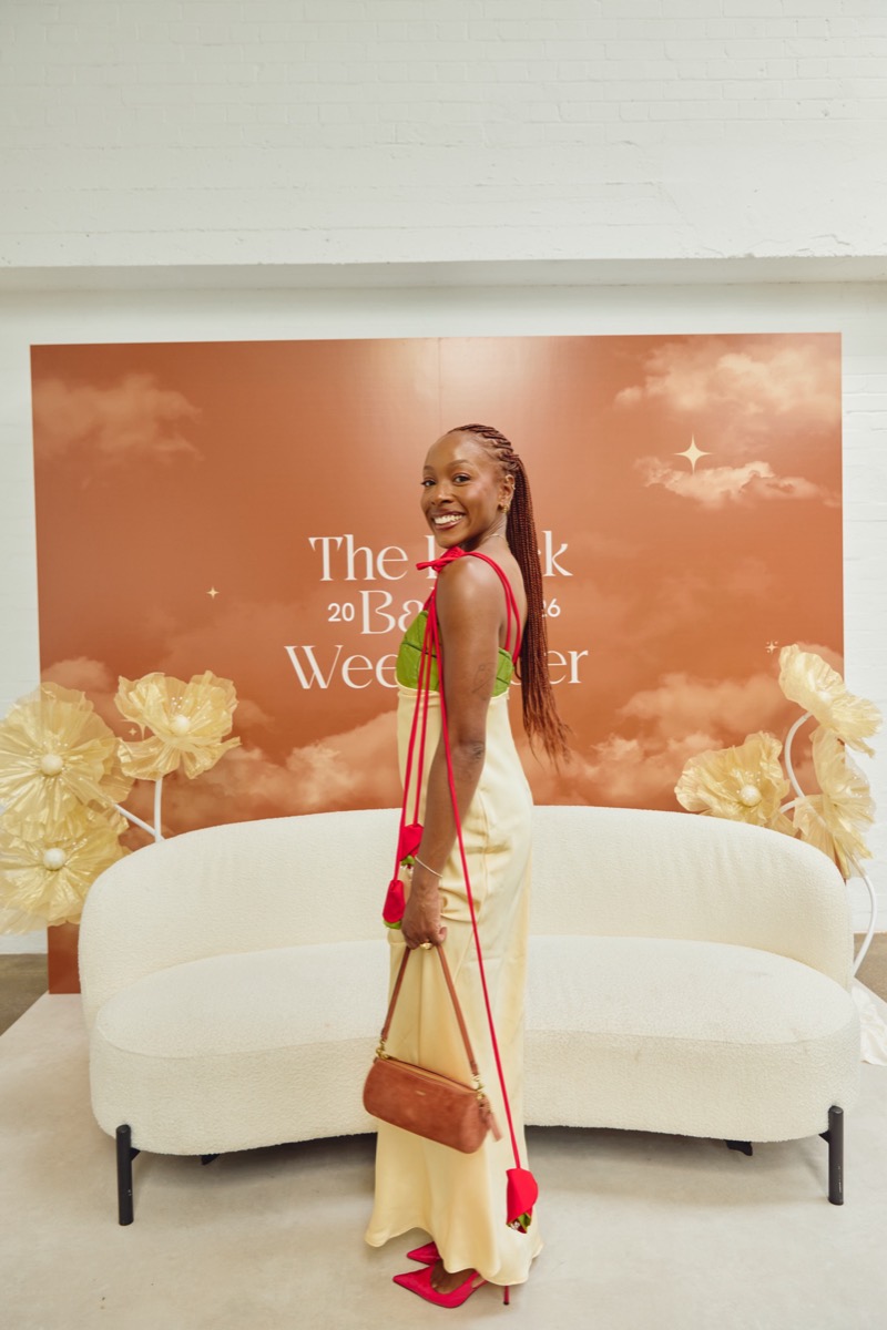A guest posing at the Weekender photo wall